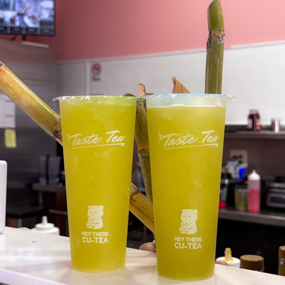 Two sugar cane juice drinks with cane stalks in Taste Tea cups
